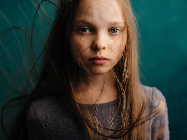Klein meisje los haar close-up groene achtergrond emoties depressie — Stockfoto
