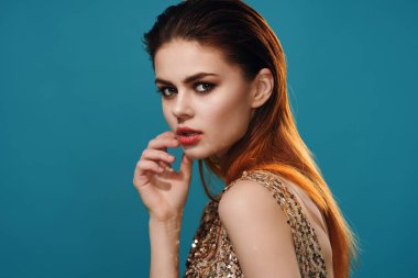 Güzel bir kadın mavi arka plan pozu veriyor.