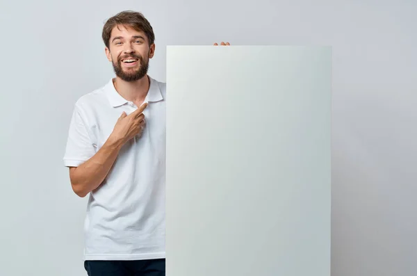 Веселий чоловік білий банер в руці чистий аркуш презентація copy-space studio — стокове фото