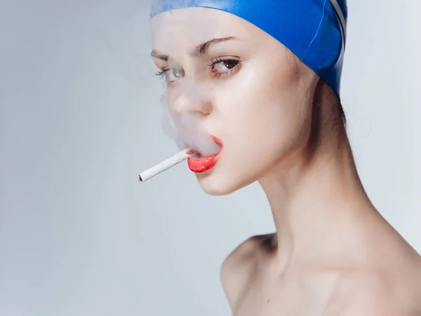 Mujer atlética en una gorra de natación fuma una piscina de fitness cigarrillo — Foto de Stock