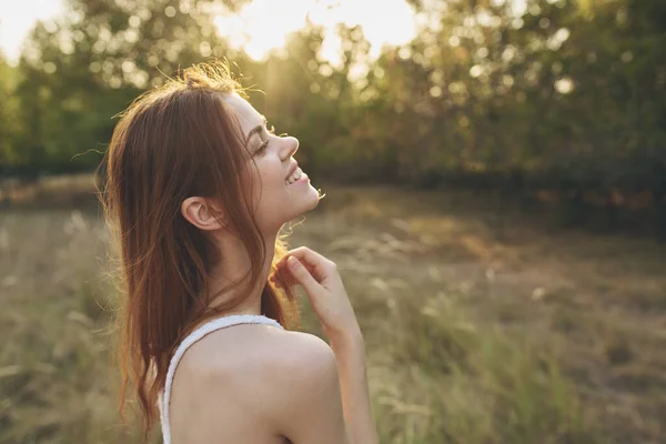Attraktiv kvinna på ett fält i naturen sol frihet — Stockfoto