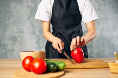 Siyah önlüklü kadın evde vejetaryen salata diyeti yapıyor.