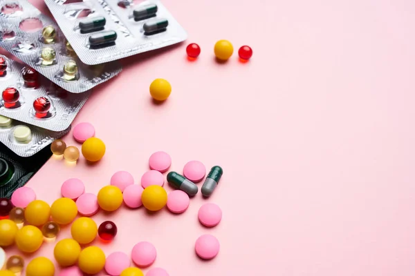 Barevné pilulky balení vitamíny zdravotní péče růžové pozadí — Stock fotografie