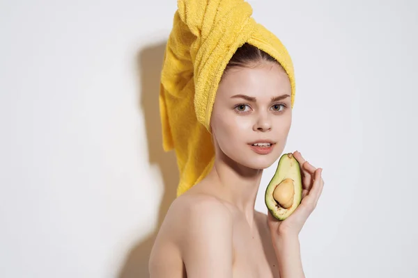 Mulher com toalha amarela na cabeça abacate limpo pele fruta dieta — Fotografia de Stock