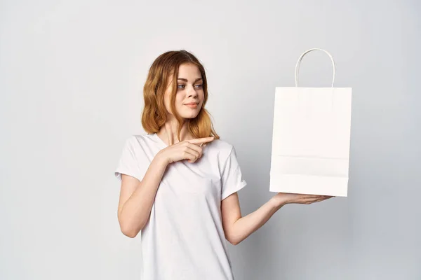 Woman with a white package in her hands makes a purchase in a lifestyle store — Stock Photo, Image