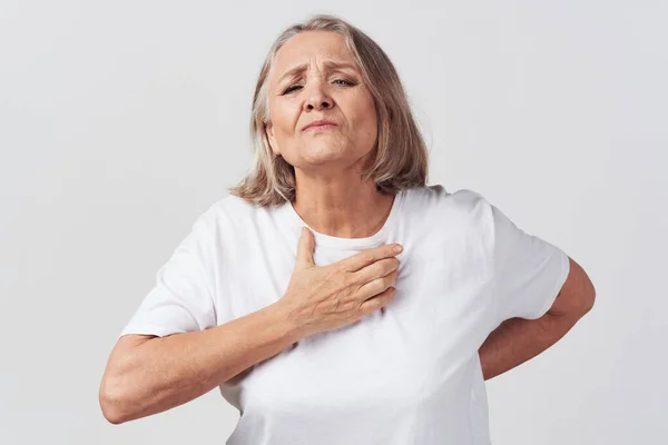 Starsza kobieta w białej koszulce problemy zdrowotne leczenie niezadowolenie — Zdjęcie stockowe