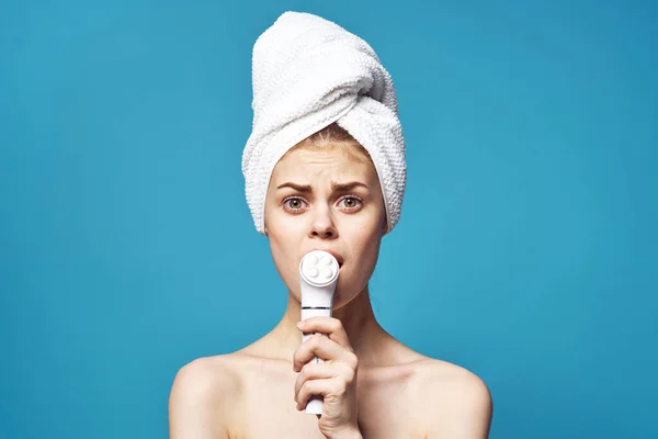 Woman with towel on head naked shoulders massager cosmetology skin care — Stock Photo, Image