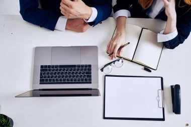 Yöneticiler ofiste dizüstü bilgisayar yetkilileriyle takım çalışması yapıyor