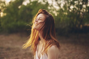 Sahada beyaz elbiseli neşeli bir kadın.