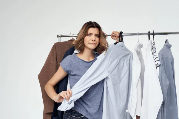 Érzelmi nő ruhák vállfa komód divat belső fény háttér — Stock Fotó