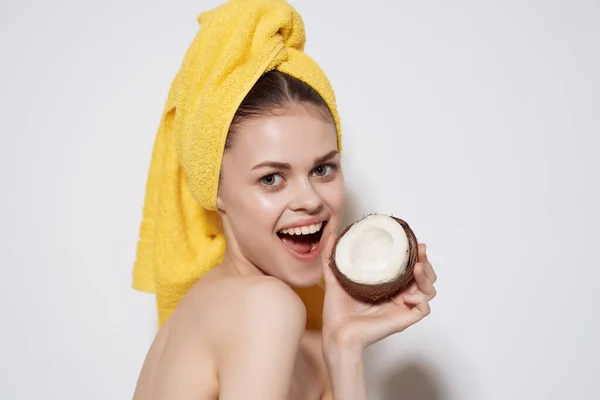 Wanita cantik dengan handuk kuning di kepalanya perawatan spa kelapa — Stok Foto