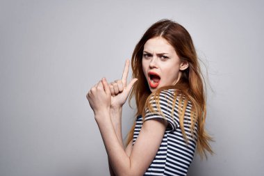 Çizgili tişörtlü hoş bir kadın. Arka planı aydınlık.