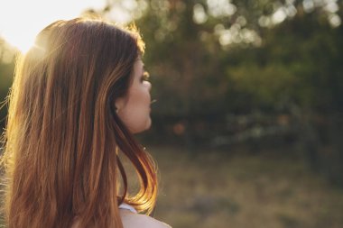 Beyaz elbiseli neşeli kadın doğa temiz hava alıyor.