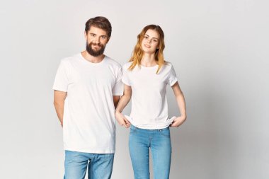 Beyaz tişörtlü ve kot pantolonlu erkek ve kadın moda fotokopi stüdyosu tasarlıyorlar.
