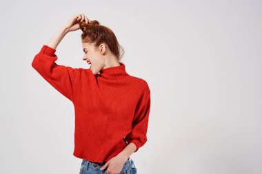 Kırmızı süveter giyen şık bir kadın.