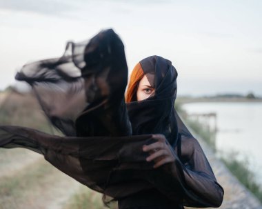 Güzel kadın siyah kumaş doğa yürüyüşü yapıyor.