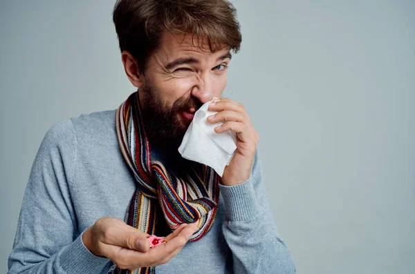 cold man with a scarf around his neck flu health problems light background