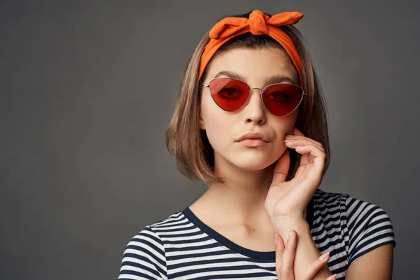 Mooie vrouw oranje hoofdband zonnebril poseren studio — Stockfoto