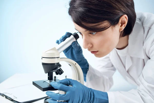 Donna che guarda attraverso un microscopio diagnostica scienza ricerca primo piano — Foto Stock