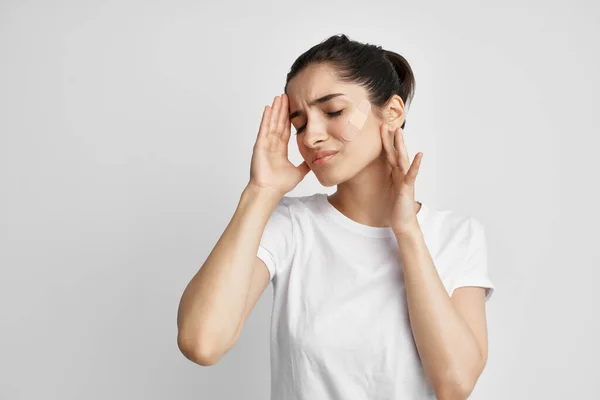 Vrouw in een wit t-shirt negatieve hoofdpijn geïsoleerde achtergrond — Stockfoto