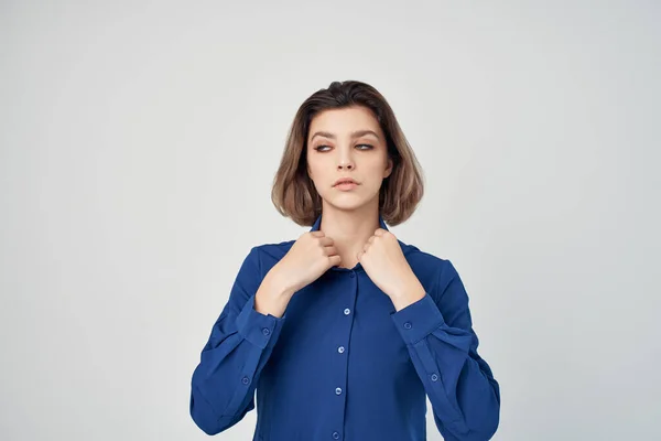 Mulher de negócios em emoções camisa azul posando fundo claro — Fotografia de Stock