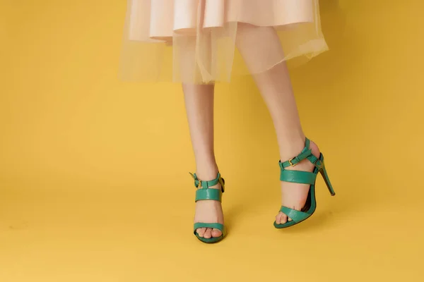 Pés femininos em sapatos verão estilo de verão fundo amarelo moda — Fotografia de Stock