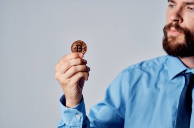 Kripto para birimini elinde tutan adam sanal para teknolojisi ekonomisi.