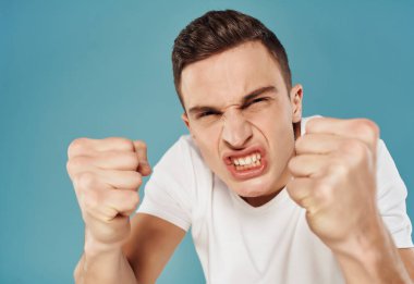 Beyaz tişörtlü bir adam ellerinde duygularıyla hareket ediyor.