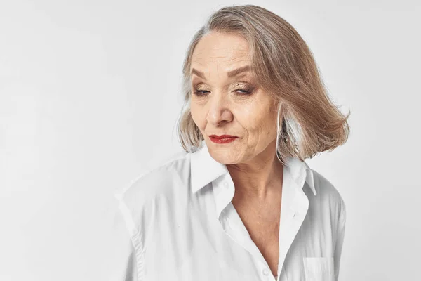 Alegre anciana mujer en blanco camisa emociones estudio estilo de vida —  Fotos de Stock