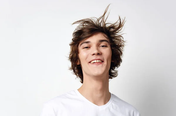 Cheerful guy with tousled hair in a white T-shirt emotions close-up — Stock Photo, Image