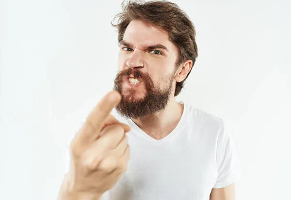 Емоційний чоловік у білій футболці жести руки гніву світлого фону — стокове фото