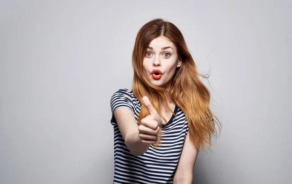 Csinos nő csíkos pólóban feldobja a kezét érzelmek piros ajkak stúdió — Stock Fotó