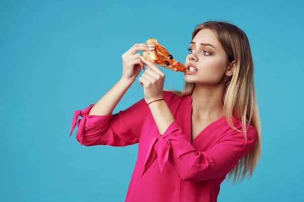 Mulher em uma camisa rosa com pizza em suas mãos junk food close-up — Fotografia de Stock