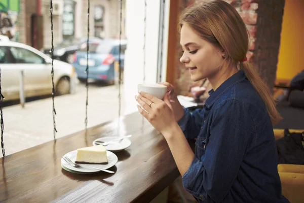 카페에서 아침 식사를 하고 식탁에 앉아 있는 아름다운 여성 — 스톡 사진