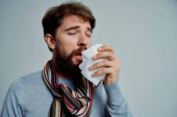 Homme malade avec une écharpe autour du cou grippe problèmes de santé arrière-plan léger — Photo