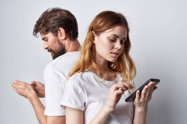 Beyaz tişörtlü erkek ve kadın ellerinde telefonlar stüdyo yaşam tarzı
