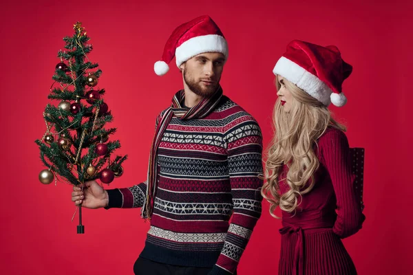 Junges Paar Weihnachtsdekoration Urlaub posiert roten Hintergrund — Stockfoto