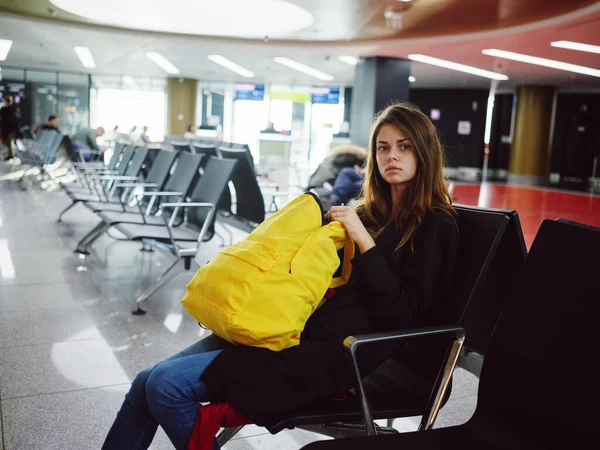 Femme avec sac à dos jaune assis à l'aéroport attente retard — Photo