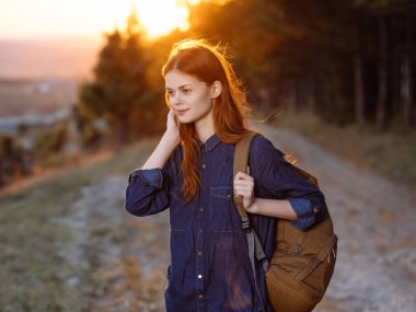 Neşeli kadın yürüyüşçü ormanda yürüyor ağaçlar seyahat ediyor