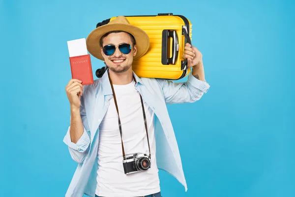 Turista masculino feliz con maleta amarilla con pasaporte y boletos de visa en la mano — Foto de Stock
