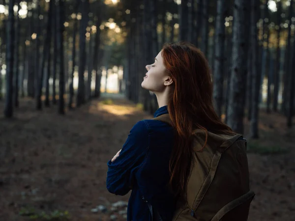 Alegre mujer pelirroja con una mochila en el bosque de viaje —  Fotos de Stock