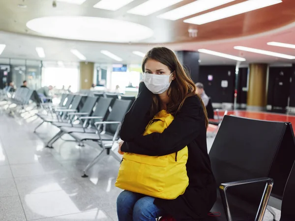 Mujer en máscara médica con equipaje aeropuerto espera retraso vuelo — Foto de Stock