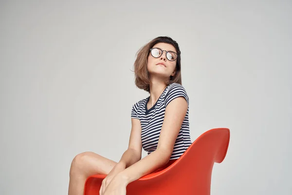 Mulher com óculos sentados na cadeira vermelha corte vista glamour — Fotografia de Stock