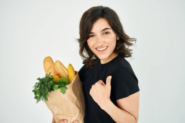 Neşeli esmer ve bir paket sağlıklı yiyecek süpermarketi.