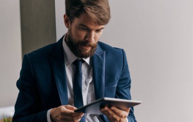 Takım elbiseli adam elinde tablet bir mesaj teknolojisi yaşam tarzı tutuyor.