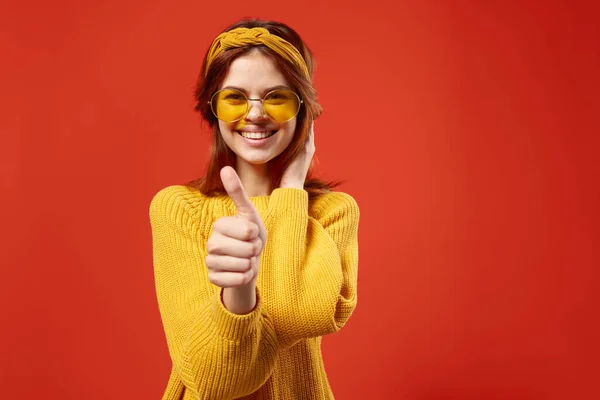 Красивая женщина в желтых очках свитер мода эмоции красный фон — стоковое фото