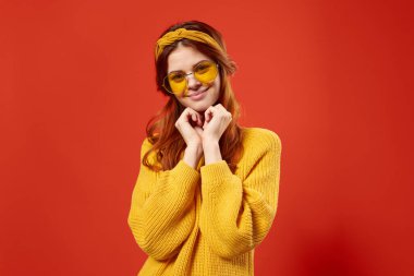 Sarı süveterli kadın hippi aksesuarları retro tarzı kırmızı arka plan