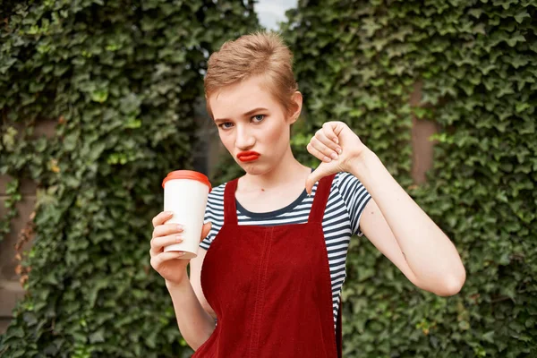 Женщина с короткими волосами чашку напитка на открытом воздухе эмоции — стоковое фото