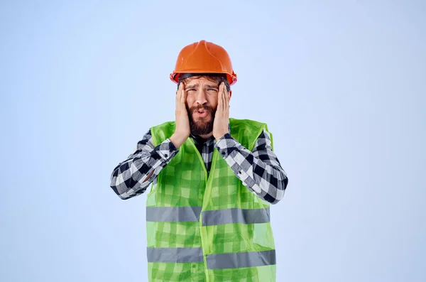 Uomo barbuto in arancio costruzione cappello duro professionale sfondo blu — Foto Stock