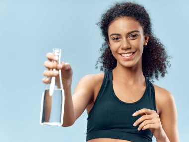 Bir şişe su ve sağlıklı bir yaşam tarzı olan sportif bir kadın.